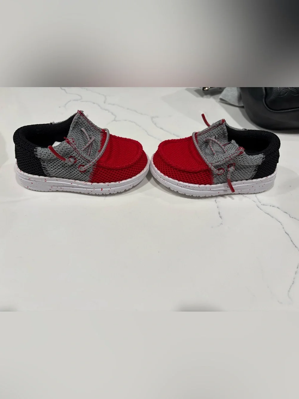 Hey Dude Kids Red and Gray Slip-On shoes.